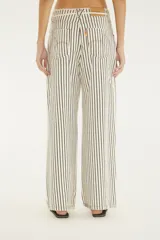 Pantalón de denim blanco con rayas verticales negras, de tiro medio y corte ancho. Cuenta con cintura ajustable con cordón y bolsillos laterales.