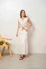 Chaleco de muselina color beige con diseño bordado marrón en la parte delantera, escote en V y cierre frontal de botones.