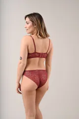Conjunto de lencería compuesto por un soutien con aro y bombacha tipo vedetina, confeccionados íntegramente en encaje floral color beige. El soutien presenta breteles regulables y un pequeño lazo decorativo en el centro, mientras que la bombacha incluye un detalle de lazo a juego en la parte frontal.