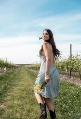 Vestido corto color celeste con espalda descubierta, tirantes finos y detalles de encaje en la cintura y el ruedo, con falda con volado.