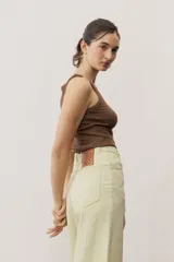 Pantalón de jean verde lima, de corte recto y tiro alto, con bolsillos traseros y etiqueta de cuero con logo en la parte posterior.