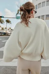 Jersey de punto liso color azul, con cuello redondo, botones delanteros y manga ancha por debajo del codo.