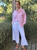 Pantalón capri de lino color blanco, con cintura elastizada ajustable con cordón y terminación con flecos.