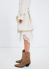Botin de estilo western confeccionado en piel bovina, con diseño de caña media, punta fina y detalle de tachas metálicas decorativas en el empeine. Cuenta con un pequeño taco cuadrado y suela de caucho.