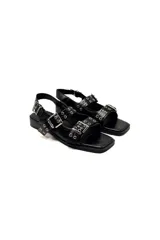 Sandalias negras de cuero con punta cuadrada, tiras con hebillas y detalles metálicos.