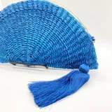 Bolso de mano azul tejido en abacá natural con forma de medialuna y cierre superior con cremallera.
