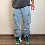 Pantalón jean celeste de corte holgado, con múltiples bolsillos cargo y cintura con presillas.