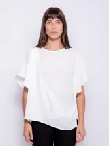 Top rosado de mangas cortas con volados, cuello redondo y detalle diagonal en el frente.