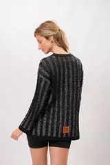 Sweater negro con lurex plateado a rayas verticales, de corte holgado y mangas largas.