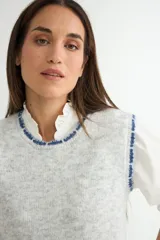 Chaleco de punto en color violeta, con cuello redondo y bordes deshilachados. Presenta una textura suave y un corte recto.