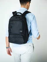 Mochila urbana color negro con múltiples compartimentos, incluyendo espacio dedicado para laptop, bolsillos laterales porta botella y enganche para valija.
