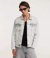 Campera de jean de hombre, color celeste claro con efecto desteñido y desgastado. Presenta cuello, manga larga, cierre frontal con botones blancos y dos bolsillos con solapa y botón en el pecho.