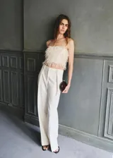 Top de diseño strapless color blanco marfil, con textura de flecos tipo plumas en todo el cuerpo y corte crop.