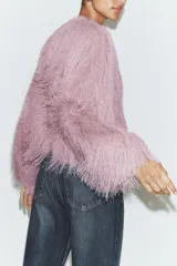 Chaqueta bomber de cuello redondo y manga larga, confeccionada con un acabado de flecos largos en toda la prenda. Presenta cierre frontal con corchetes y puños elásticos.