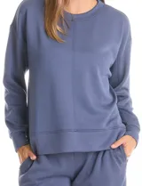 Buzo deportivo de cuello redondo, con hombros caídos y mangas largas con puños. Presenta costuras decorativas tipo pespunte en la parte frontal y en las mangas, con un diseño de ruedo recto y tajos laterales.