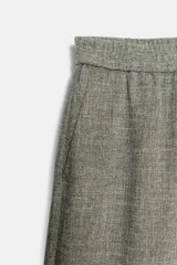 Pantalón gris melange de tiro alto y pierna ancha, con cintura elástica y bolsillos delanteros.