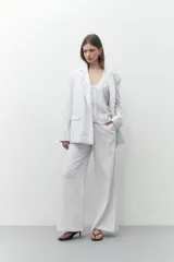 Blazer de lino color blanco, de corte oversize, con solapas de muesca y cierre con dos botones.