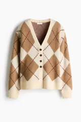 Saco tipo cárdigan de punto jacquard con diseño de rombos, escote en pico, cierre frontal con botones y hombros caídos. Presenta terminaciones acanaladas en cuello, puños y ruedo.