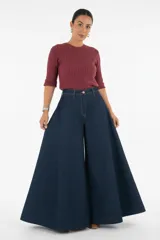 Pantalón de jean tiro alto con corte elefante, caracterizado por su silueta amplia y acampanada desde la cadera. Presenta cierre frontal con botón y costuras reforzadas.