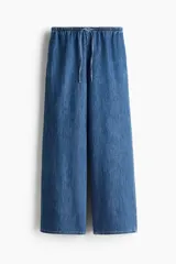 Pantalón denim de corte holgado en mezcla de lyocell y algodón, color azul. Presenta tiro alto con cintura elástica revestida y cordón ajustable, bolsillos laterales discretos y piernas rectas.