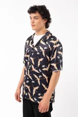 Camisa negra con estampado de grullas y flores, de manga corta y corte relajado, con cuello tipo sastre.