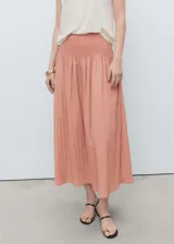 Falda midi color salmón con cintura elastizada fruncida y corte evasé.