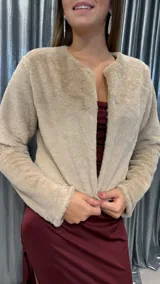 Chaqueta corta de peluche en color beige, con diseño de manga larga y frente abierto sin cierres visibles.
