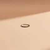 Anillo tipo alianza de oro blanco 18k con engaste de esmeraldas pequeñas en todo el frente.