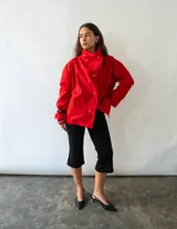Campera de algodón color rojo, con cuello alto, cierre frontal con botones metálicos y diseño versátil de corte holgado.