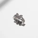Anillo plateado de acero con eslabones y diseño de mariposa cubierta de cristales claros de circonia cúbica.