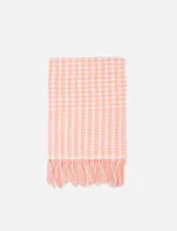 Bufanda rectangular de poliéster con estampado de cuadrillé en tonos rosa y blanco, con flecos en los extremos.