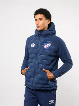 Campera Umbro del Club Nacional de Football, modelo Alpine. Diseño en color azul marino con frente acolchado termosellado, mangas y espalda de tejido polar, capucha integrada y cierre frontal completo. Incluye logo de Umbro y escudo del club en el pecho.