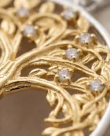 Dije circular de plata 925 con baño de oro, presentando un diseño calado del Árbol de la Vida adornado con circonias.