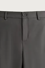 Pantalón regular fit de hombre color negro, confeccionado en tejido técnico ligero con cintura elástica, bolsillos frontales, bolsillos traseros de vivo y cierre frontal con cremallera y botón.