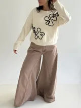 Sweater de punto color marrón chocolate con diseño floral bordado en cordón color crudo. Presenta cuello redondo, mangas largas y puños acanalados.