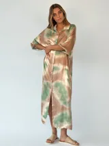 Vestido camisero midi con botones, de corte recto y mangas 3/4. Estampado con efecto tie-dye en tonos marrones, verdes y beige.