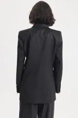 Saco negro de lana con solapa de satén y bolsillos con tapa.