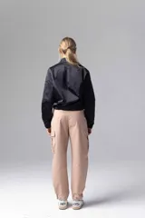 Chaqueta bomber negra con cierre frontal de botones a presión y bolsillos laterales.