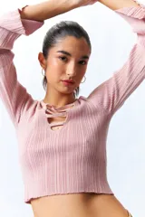 Top negro de tejido de punto con escote en V con tiras horizontales y mangas largas acampanadas.