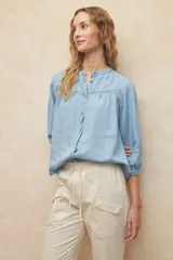 Pantalón color beige de algodón, tipo paper touch, con elástico en la cintura y cordones. Tiene un fit recto con bolsillos de solapa y botones a tono.