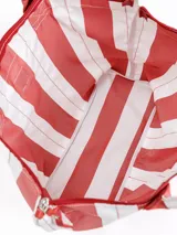 Bolso tipo tote grande, resistente al agua, con diseño de rayas verticales rojas y blancas. Cuenta con asas largas de hombro, cierre superior y parche de cuero con logo grabado. Incluye neceser transparente a juego con base y detalles a rayas.