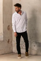 Camisa celeste de manga larga con cuello clásico y cierre frontal con botones.