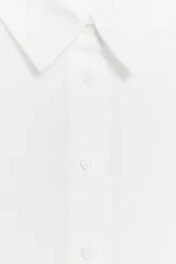 Camisa de lino de corte clásico con cuello solapa, manga larga con puños anchos y cierre frontal con botones.