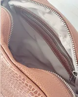 Bandolera marrón de cuero con correa larga regulable, cierre metálico y llavero de cinta.