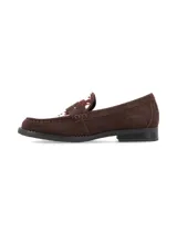 Mocasines de gamuza marrón con detalle de cuero vacuno con estampado de manchas en la parte superior. Presentan una banda frontal característica de los mocasines tipo penny y suela plana de goma.