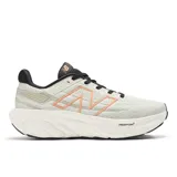 Championes de running New Balance Fresh Foam X 1080 V13 para mujer. Capellada de malla y sintético color crema con logo "N" delineado en naranja. Entresuela Fresh Foam X blanca y suela de goma negra.
