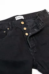 Jean negro de corte clásico con cinco bolsillos, botones color cobre y confeccionado en algodón 100% sin elastano.