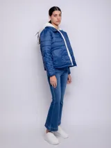 Campera puffer azul con capucha y peluche blanco en el interior, bolsillos laterales a tono.