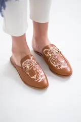 Mocasines color camel con detalle de tigre bordado en hilo color crema y aplique metálico dorado.