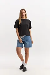 Remera oversize de algodón en color negro con efecto lavado, cuello redondo y mangas cortas.